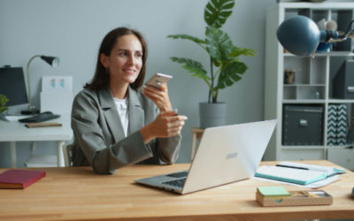 lady holding phone while working on a laptop